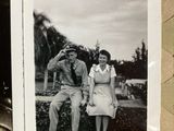 a black and white photo of a man and a woman sitting on a bench