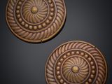 a pair of carved wooden buttons on a black background