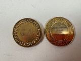 two gold colored coins sitting next to each other on top of a white surface