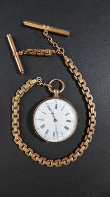 une montre de poche attachée à une chaîne, posée sur une table