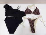 two bikinis and a bathing suit laying on a table