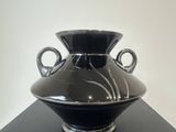 a black vase sitting on top of a black table