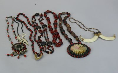 several necklaces and pendants are displayed on a table