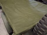 a military vehicle with a green tarp on the back of it