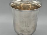 a silver cup on a pedestal on a gray background