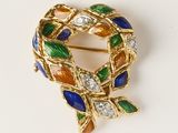 une image représentant une broche en or sertie de pierres multicolores
