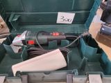 un outil dans une boîte verte sur laquelle est accrochée une étiquette de prix