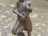 figurine en bronze représentant un homme coiffé d'un turban et tenant une canne