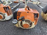 two chainsaws sitting next to each other on the ground