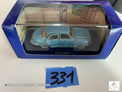 La petite voiture bleue se trouve dans la boîte posée sur la table.