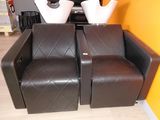 deux fauteuils en cuir marron sur lesquels sont posés des vases blancs