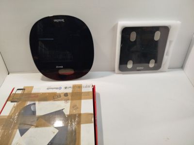 une horloge en noir et blanc et un livre posés sur une table blanche