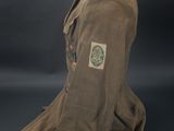 a brown jacket with a green patch on the chest
