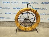 an image of a coil of yellow wire on a stand in front of a wall