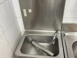 un lavabo situé dans un coin de la salle de bains, équipé d'un robinet