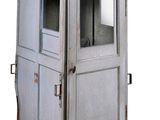 une vieille toilette extérieure munie d'une porte et d'une fenêtre