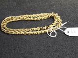 a close up of a gold chain with a tag on it