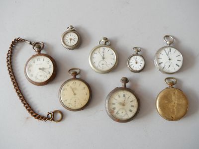 many different types of pocket watches displayed on the table