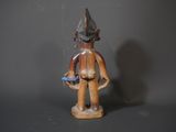 a small wooden figure of a man with a bird in his hand