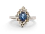 un gros plan d'une bague sertie d'un saphir bleu entouré de diamants