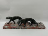 a pair of black cats on a marble base with a white background