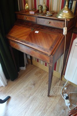 un petit bureau sur lequel est posée une lampe, dans une pièce