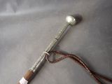 a metal spoon with a wooden handle on a gray surface