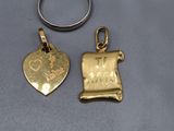 deux bijoux en or et en argent posés sur une surface grise