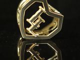 a close up of a gold ring with the letter f on it