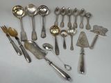 de nombreuses cuillères et couverts en argent disposés sur une table