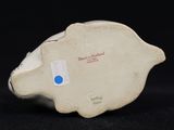 porcelain figurine of a pig with a blue dot on its face