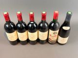 six bottles of red wine lined up in a row