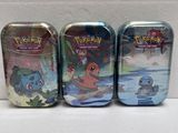 three tins of pokemon tins sitting on top of a table