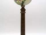 une lampe à l'ancienne, décorée de fleurs peintes sur fond blanc