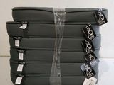 quatre bagages emballés dans du plastique, posés sur une surface blanche