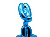 the blue rabbit statue is sitting on top of a white surface