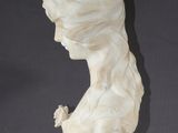 a white marble bust of a woman with a flower in her hair