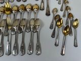 many silver spoons and forks arranged together on a table