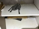 a picture of a cluttered kitchen cupboard with knives and utensils on it