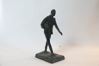 une statue représentant un homme debout sur un socle