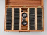 a wooden box that has a bunch of hair brushes in it