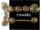 a close up of a black box with a gold chain and a chanel bracelet