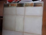 a red and white sign on top of a tile wall