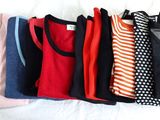 beaucoup de t-shirts qui traînent sur un lit