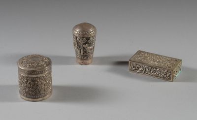 trois objets métalliques argentés posés sur une surface blanche