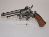 an old revolver with a wooden handle on a white surface