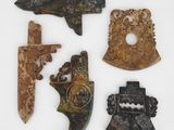Quatre types différents d'objets sculptés sont exposés sur une surface blanche