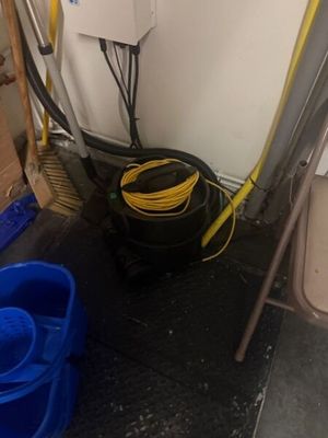 an image of a bathroom with a toilet and a bucket of water