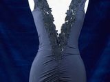 une robe posée sur un mannequin, avec un fond bleu