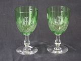 deux verres à vin verts posés l'un à côté de l'autre sur une table